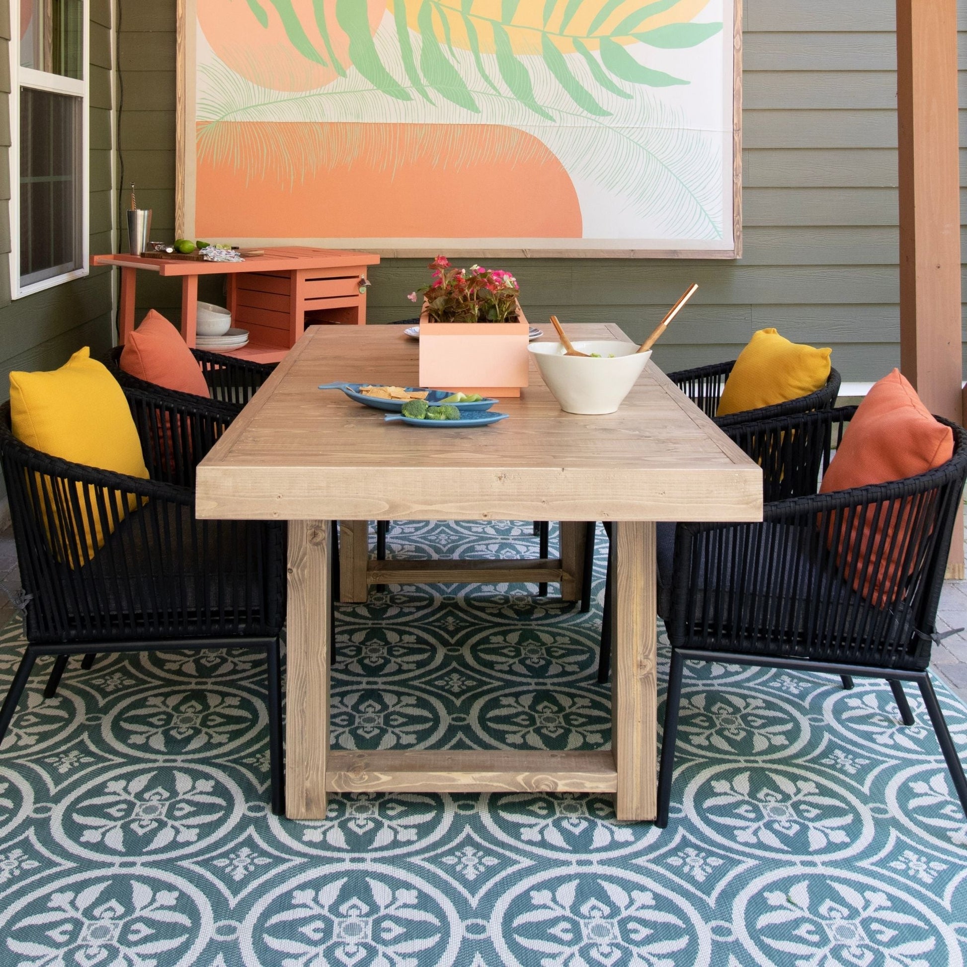 Outdoor Dining Table in a styled outdoor living room with black chairs