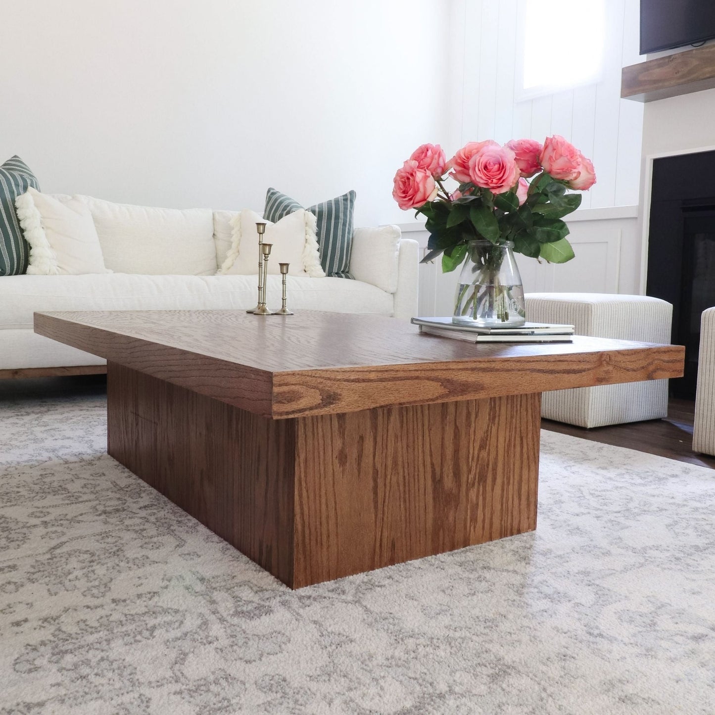 Coffee Table with Storage sitting on a gray rug next to a white couch with pink flowers sitting on top