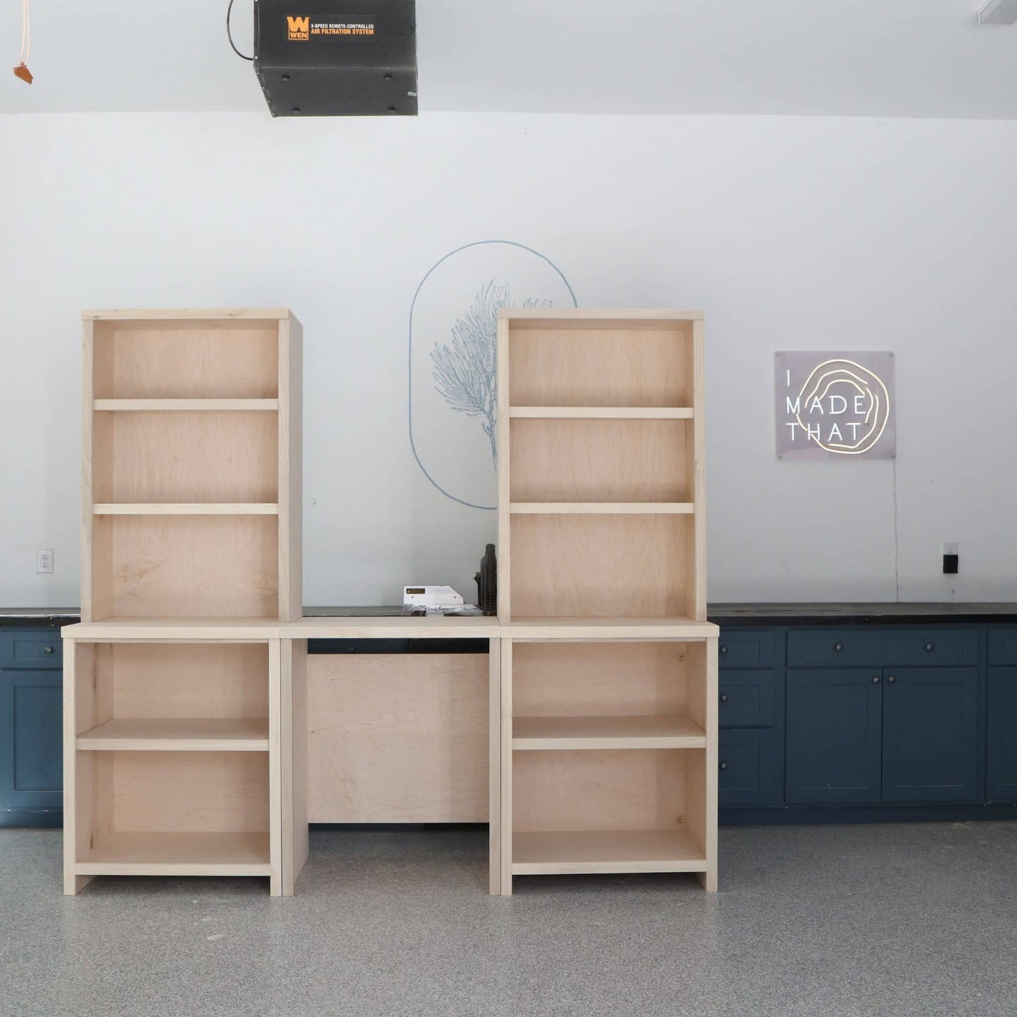 two tall DIY wooden bookcases with desk in the middle