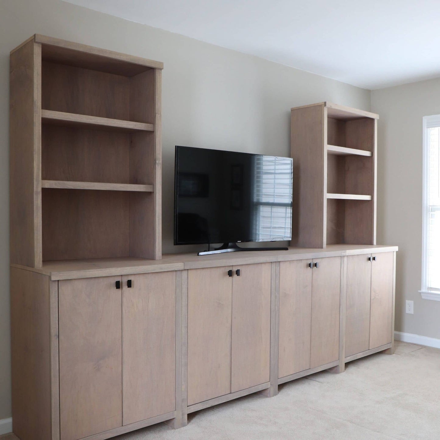 DIY entertainment center with shelves and cabinets in a room.