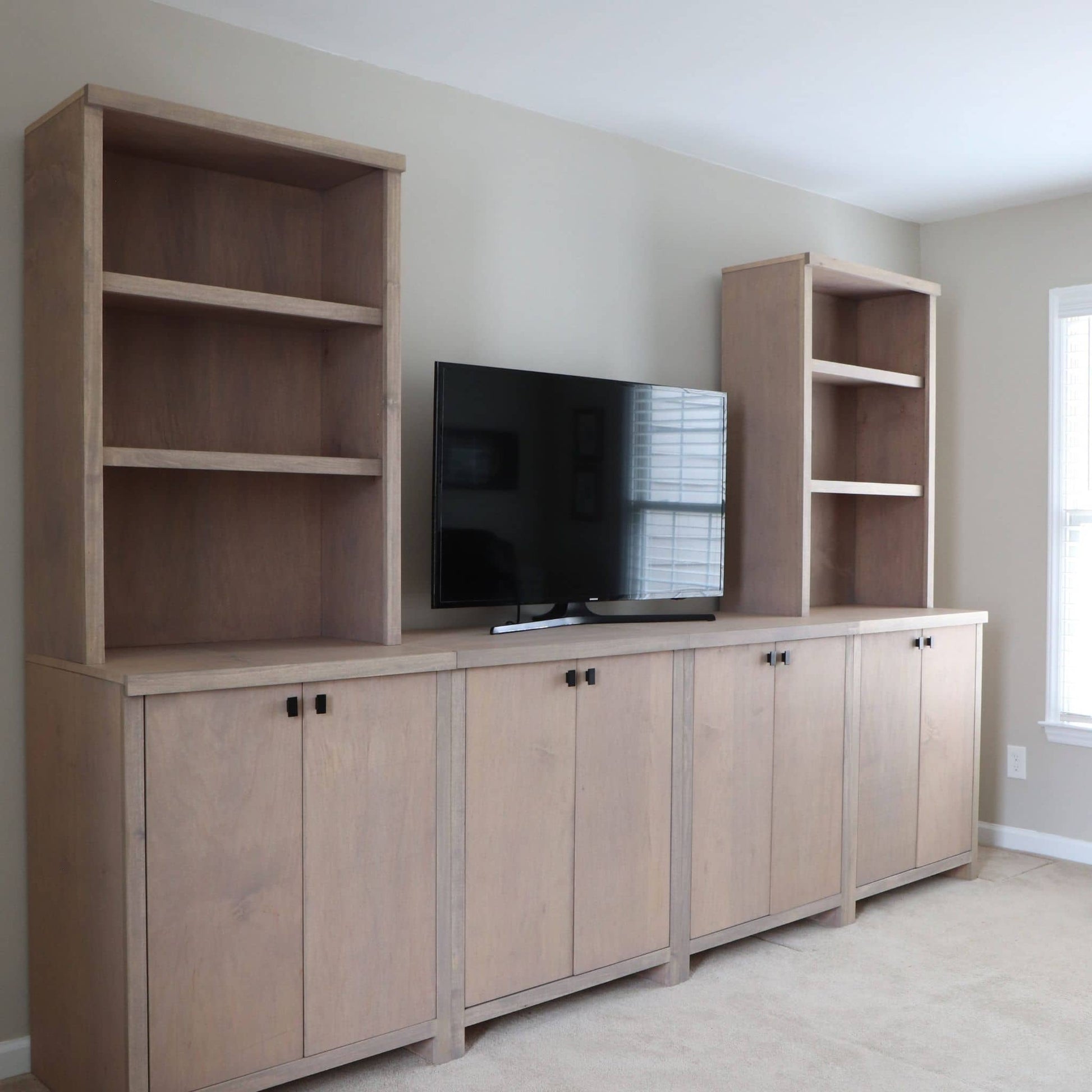 DIY entertainment center with shelves and cabinets in a room.