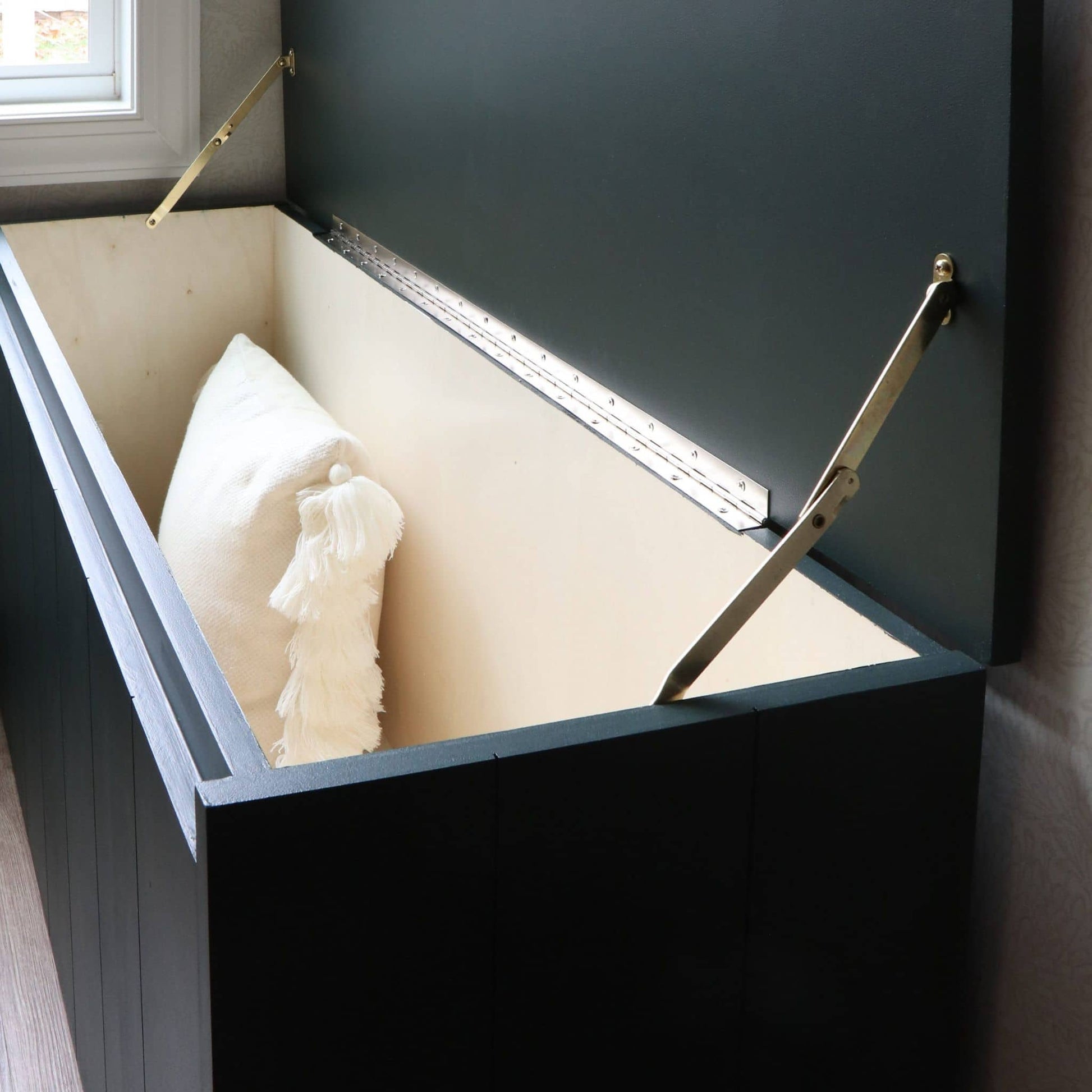 DIY storage box with a lid open, revealing white pillows inside.