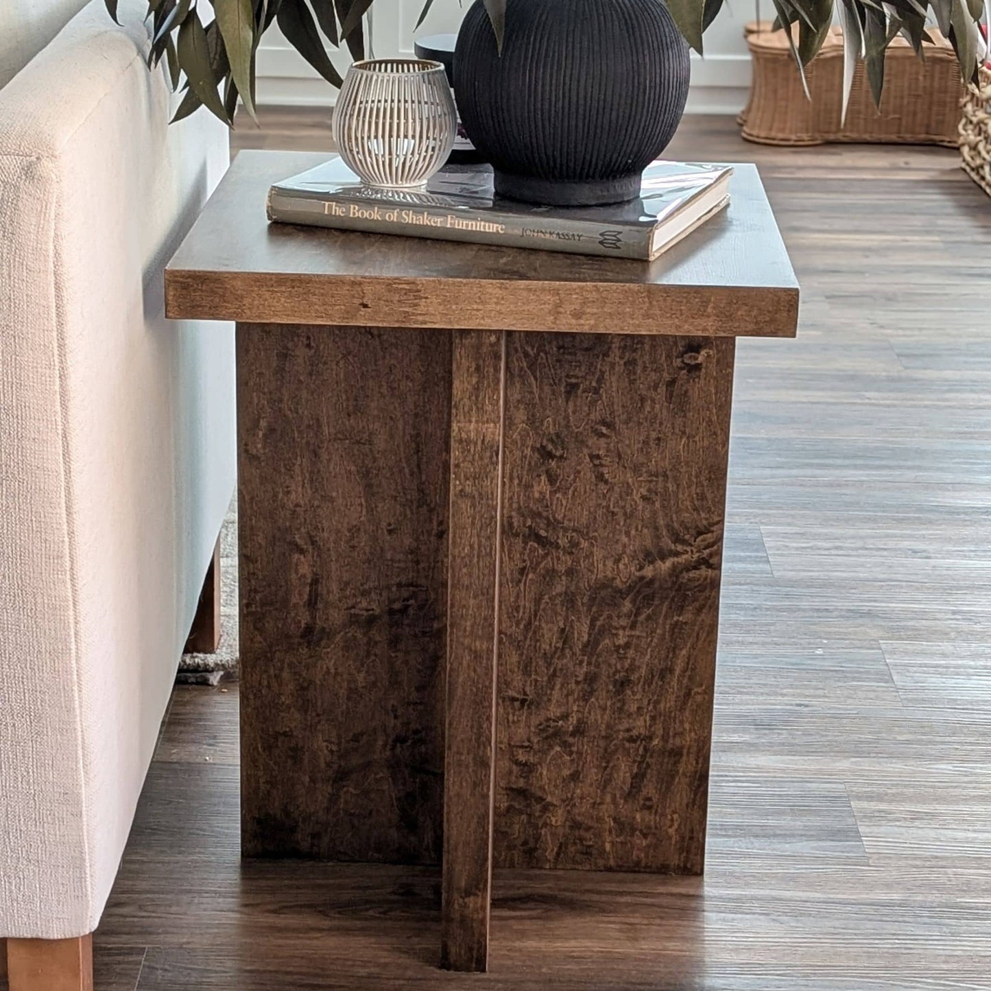 Wooden side table with decorative items in a living room setting