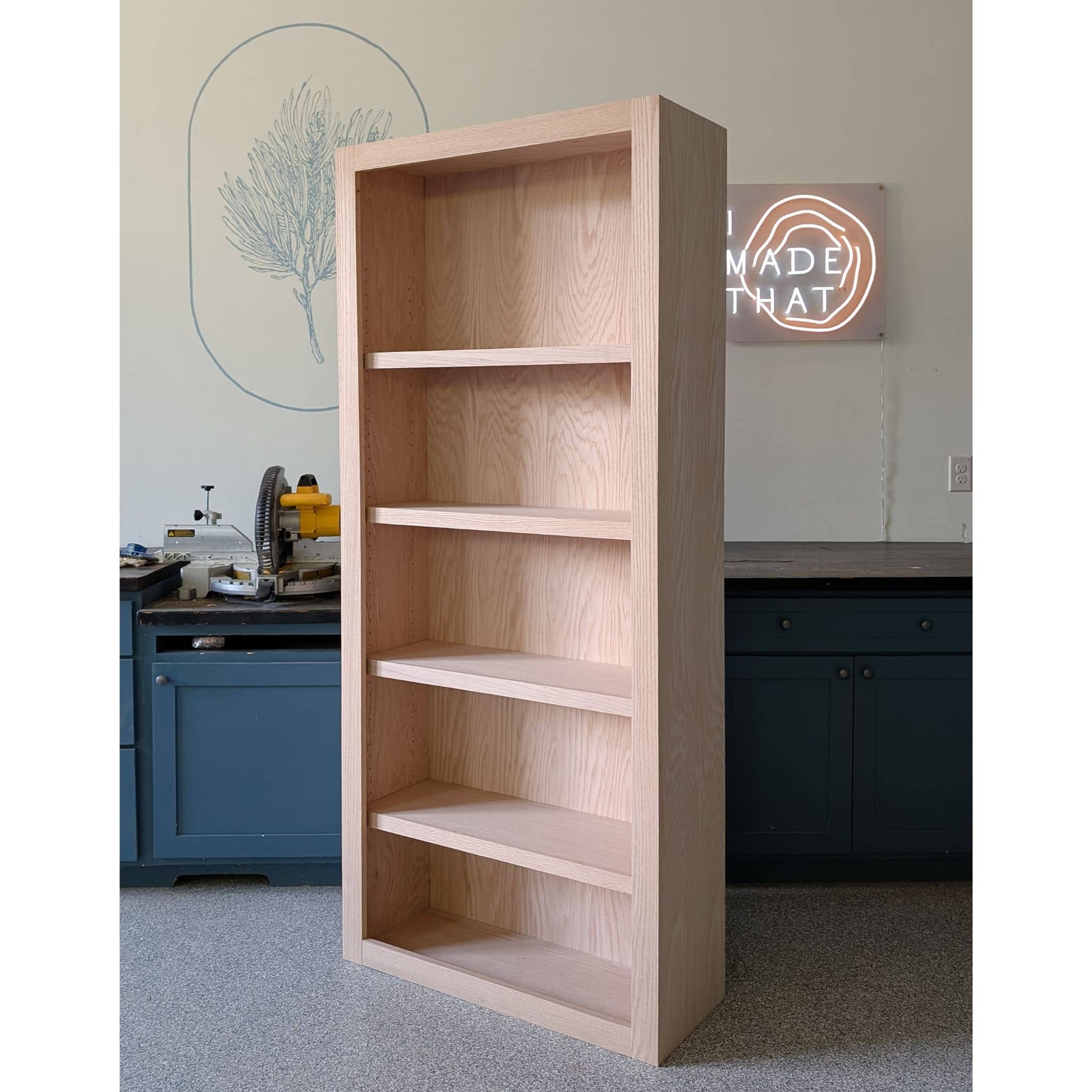 DIY red oak bookshelf in a workshop with tools 