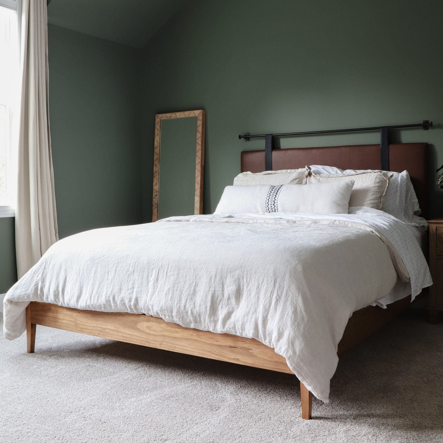 DIY bed frame with tapered legs in green bedroom