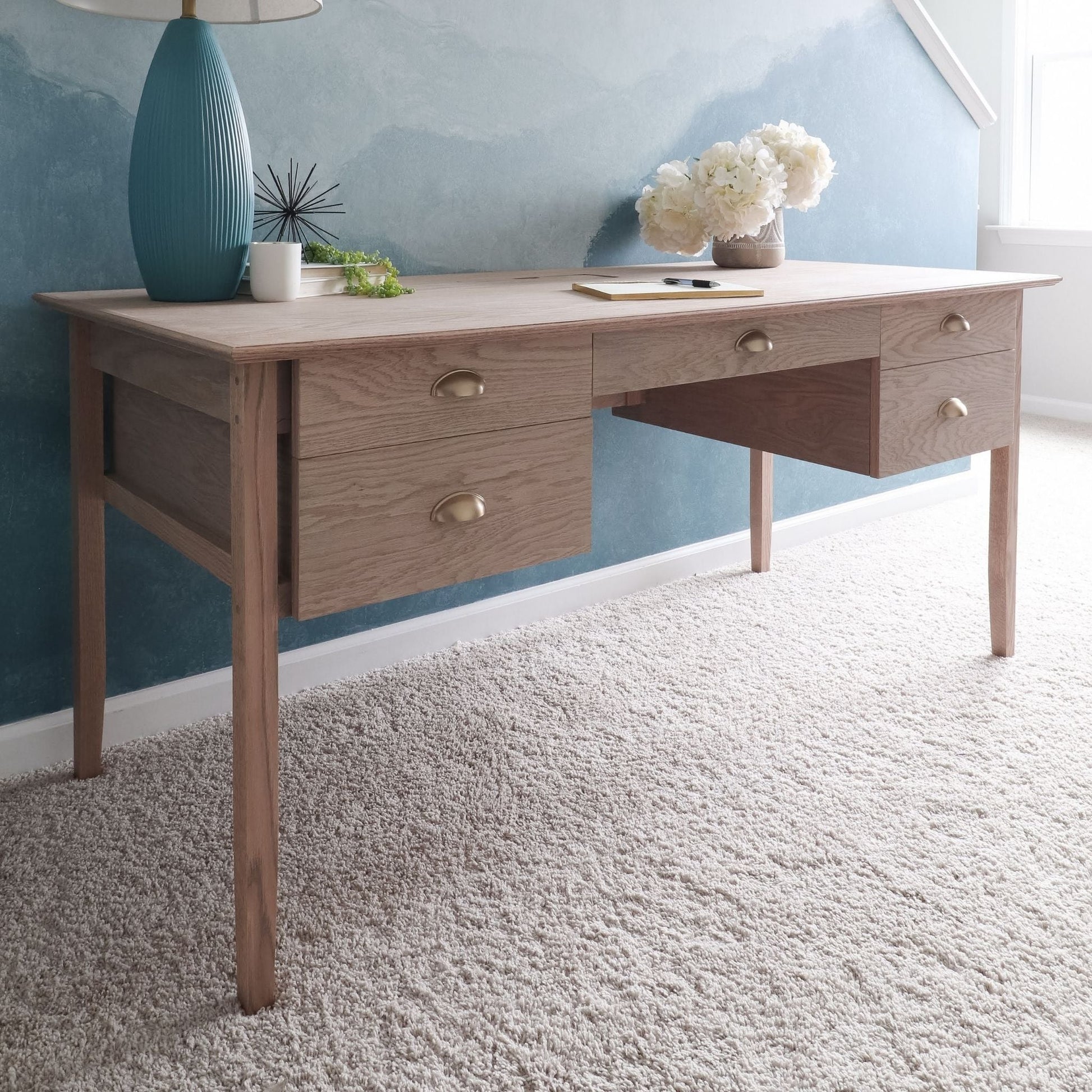 Desk with Drawers decorated in front of a blue wall