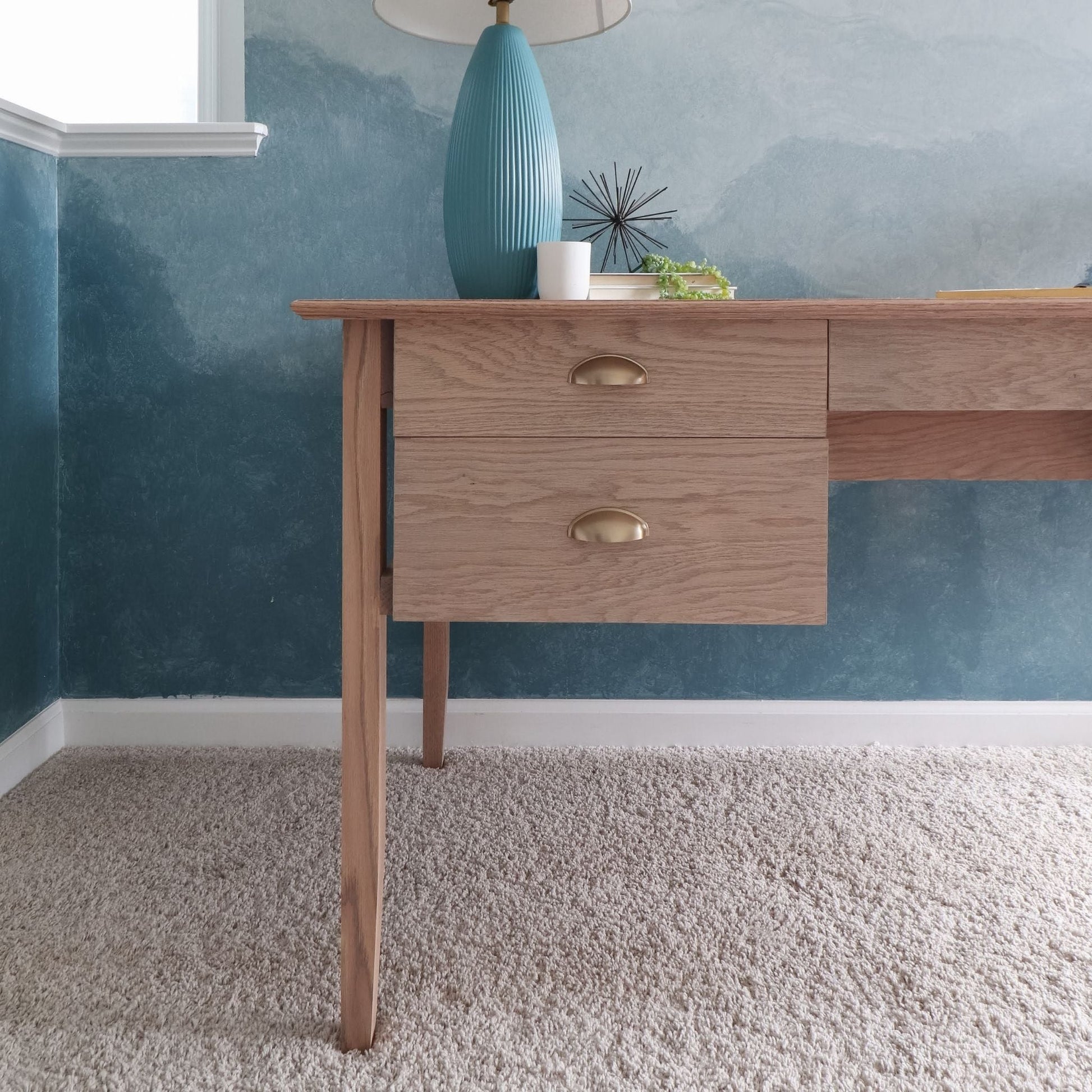 Desk with Drawers close up stained in front of a blue wall