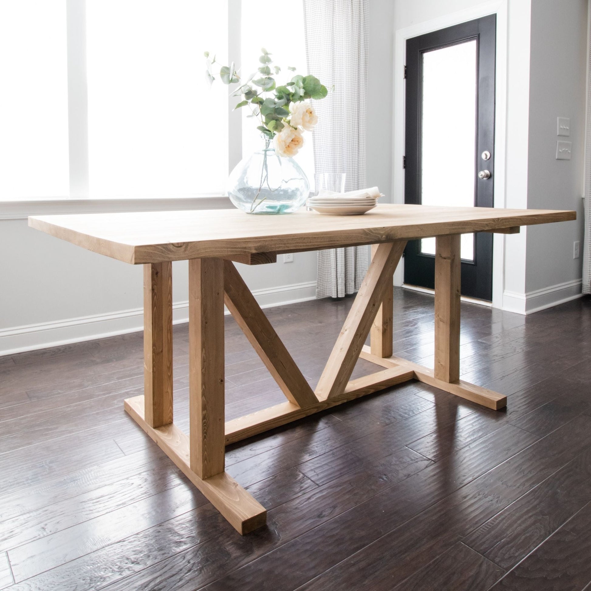 Dining Table unstained inside a dining room with bright windows