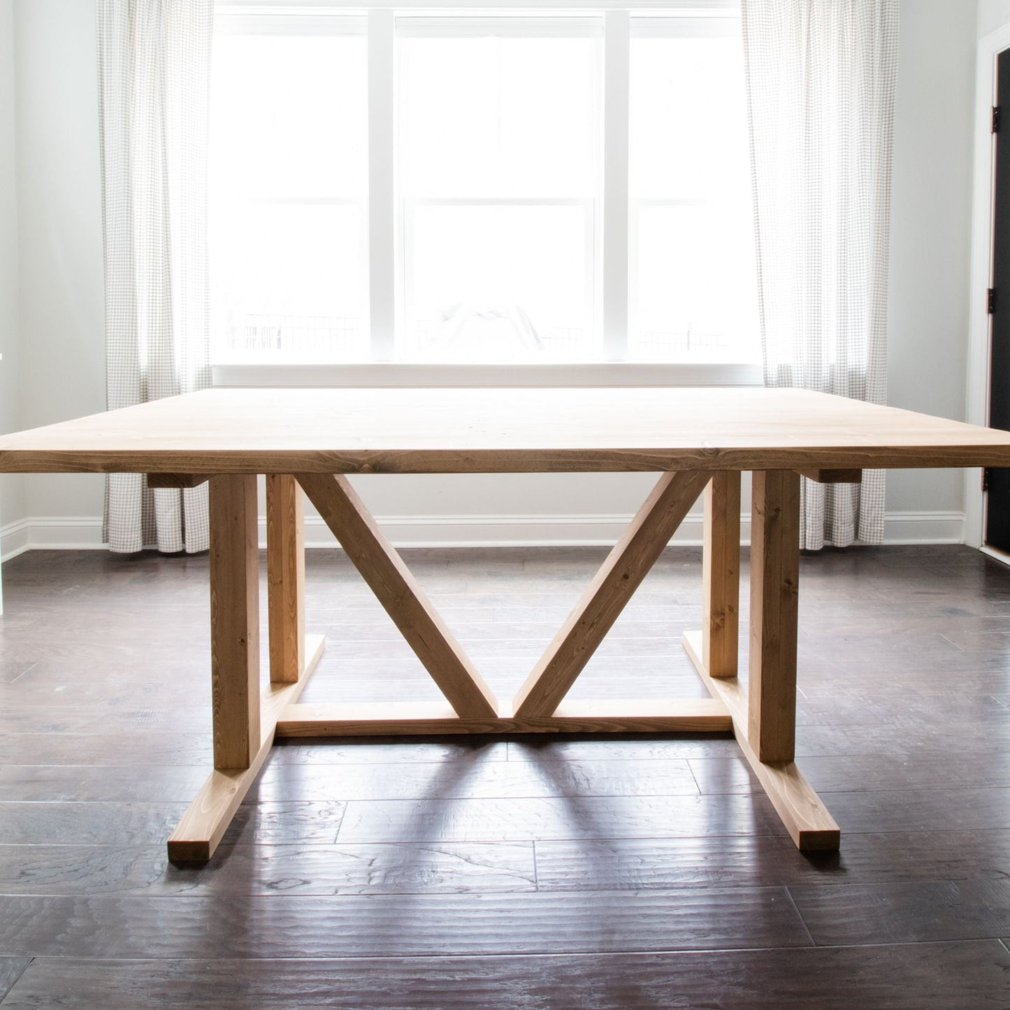 Dining Table unstained in a dining room with bright windows