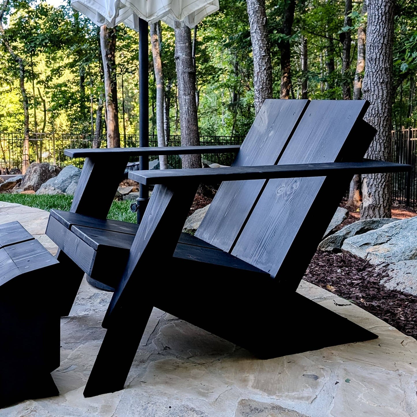 Modern Adirondack Chair stained black sitting outside