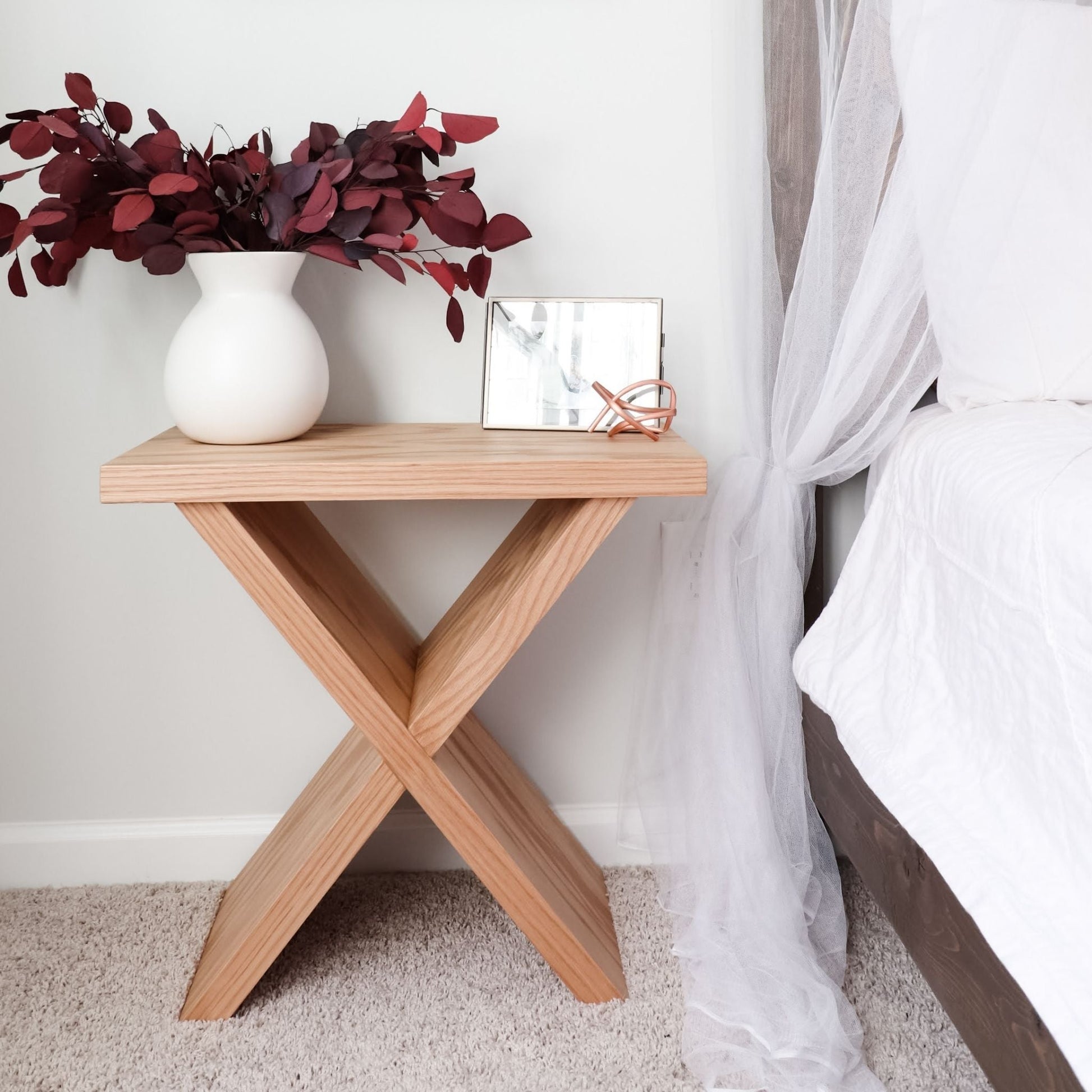 X-Side Table decorated next to a bed